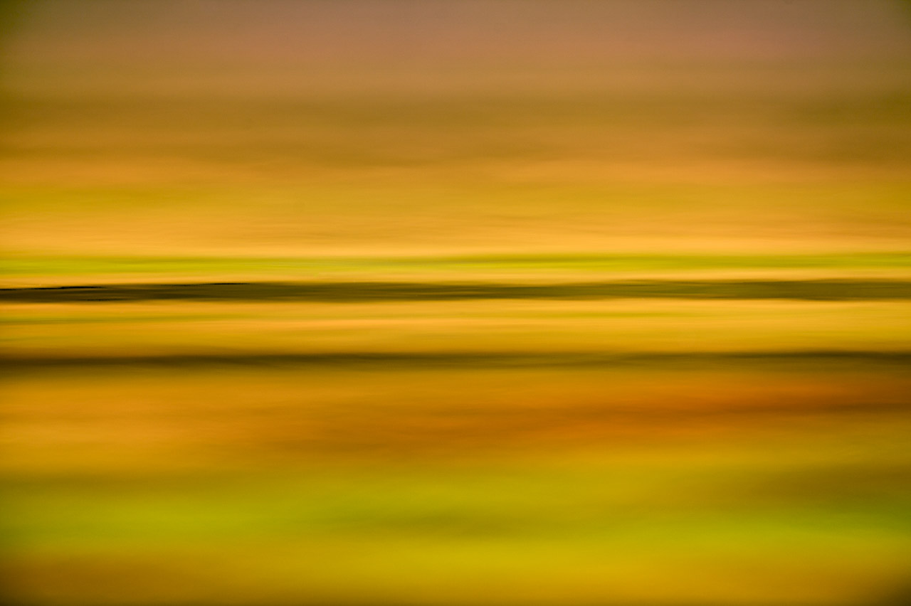 Les lignes horizontales à la surface de l'eau avec des tons chauds créent une photographie douce et apaisante.