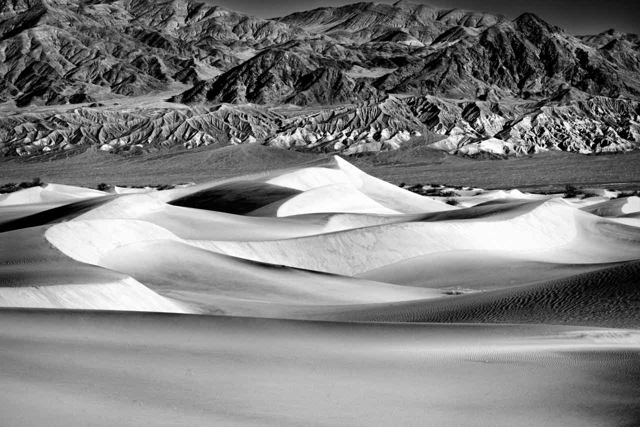 Photo en noir et blanc des dunes de la Vallée de la Mort en Californie. Photographie par Amar Guillen, artiste photographe.