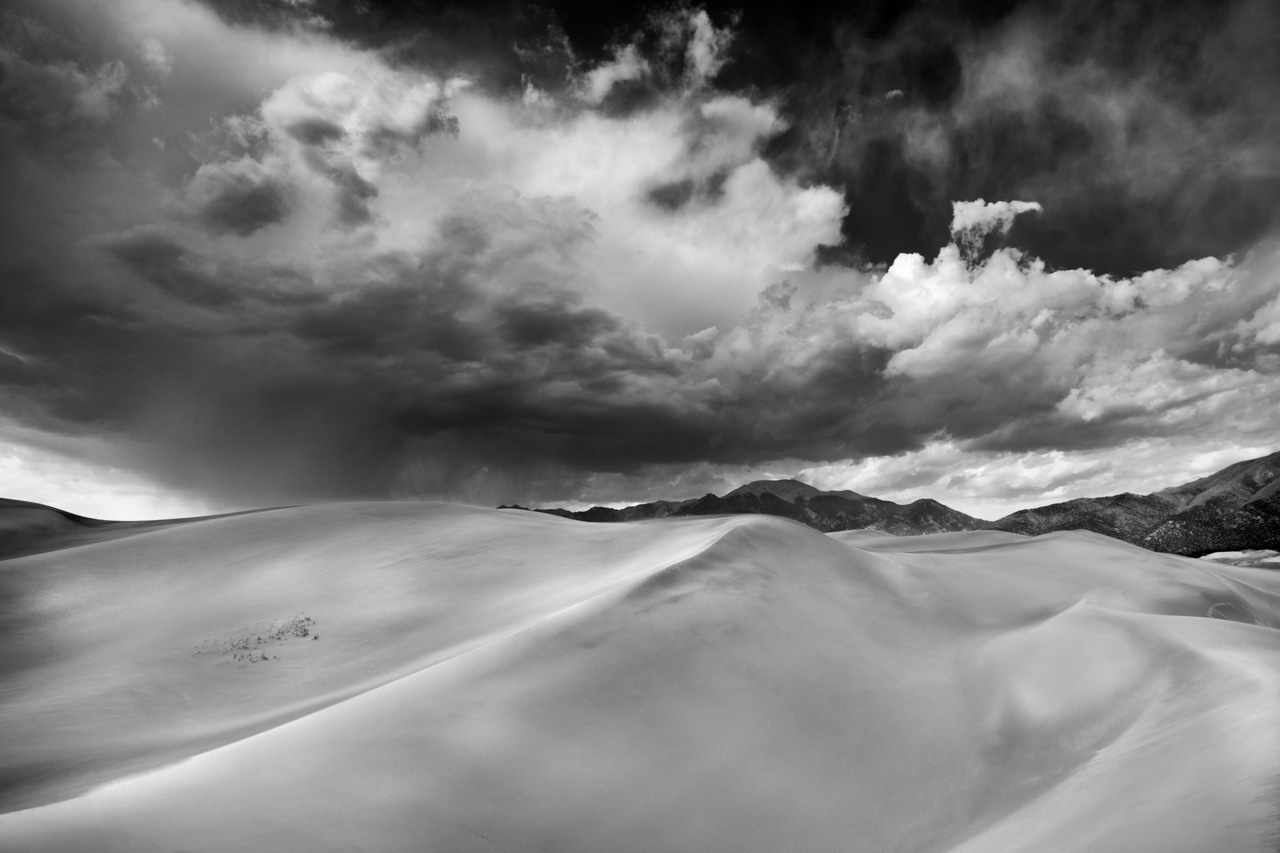 Tempête sur les dunes de sable de Great Sand Dunes dans l'état du Colorado aux Etats-Unis. . Photo en noir et blanc par Amar Guillen.