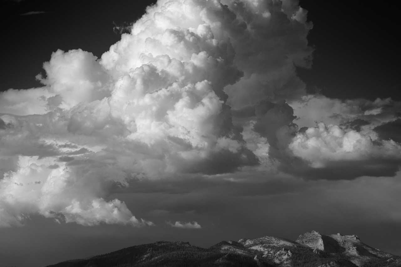 Nuages au dessus de Half Dome dans le parc national du Yosemite en Californie aux Etats-Unis. Photographie d'art en noir et blanc par Amar Guillen, artiste photographe.