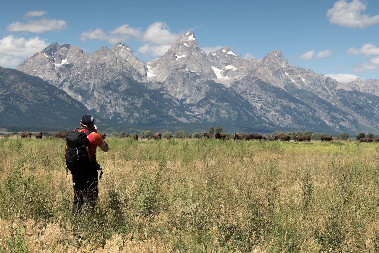 Serge, un des participants au stage au Yellowstone en août 2019. Il photographie des bisons avec le Grand Teton en arrière-plan.
