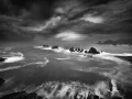 Seascape of Asturias in Spain in black and white.The waves of the Atlantic Oceans break on the rocks of the shore or on the cliffs.
