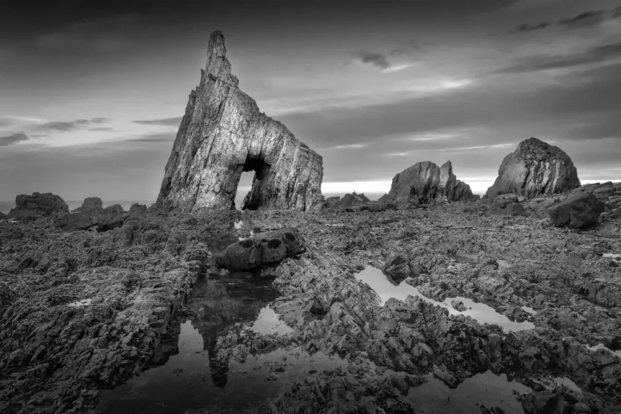 Seascape of Asturias in Spain in black and white.The waves of the Atlantic Oceans break on the rocks of the shore or on the cliffs.
