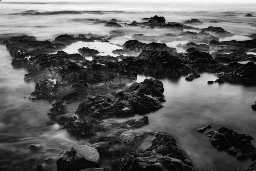 Seascape of Asturias in Spain in black and white.The waves of the Atlantic Oceans break on the rocks of the shore or on the cliffs.