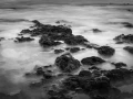 Seascape of Asturias in Spain in black and white.The waves of the Atlantic Oceans break on the rocks of the shore or on the cliffs.