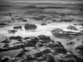 Seascape of Asturias in Spain in black and white.The waves of the Atlantic Oceans break on the rocks of the shore or on the cliffs.
