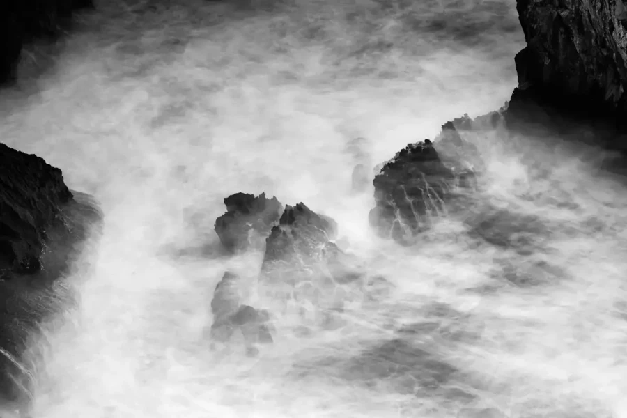 Seascape of Asturias in Spain in black and white.The waves of the Atlantic Oceans break on the rocks of the shore or on the cliffs.