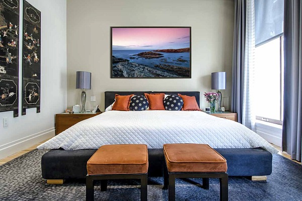 A fine art print showing a seascape of Scotland displayed in a master bedroom.