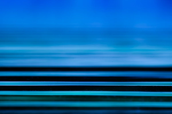 Photo abstraite de vaguelettes à la surface de l'eau. Les lignes horizontales donnent de la quiétude à la photo. Elles sont apaisantes.