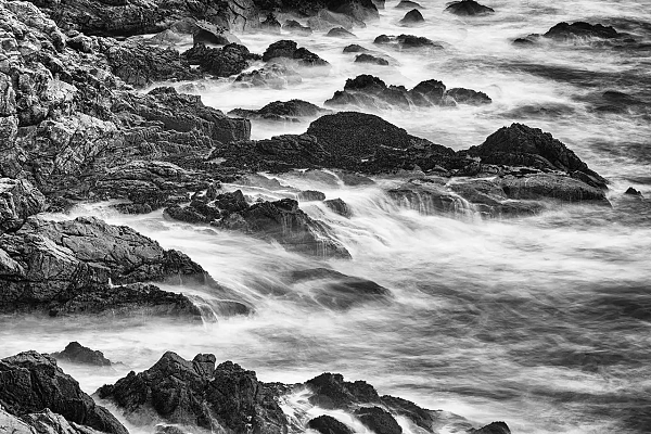 Waves crashing on rocks in the Atlantic Ocean on the coast of South Finistere in Brittany in France. Fine art Photograph in black and white by Amar Guillen, photographer artist.